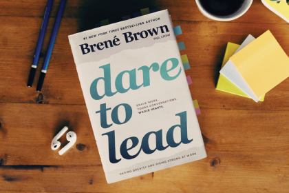 Dare to Lead book by Bren茅 Brown on a wooden table